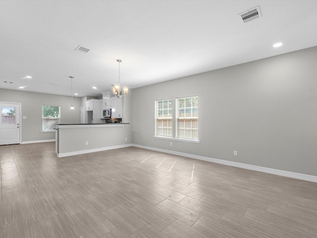 unfurnished living room with a chandelier