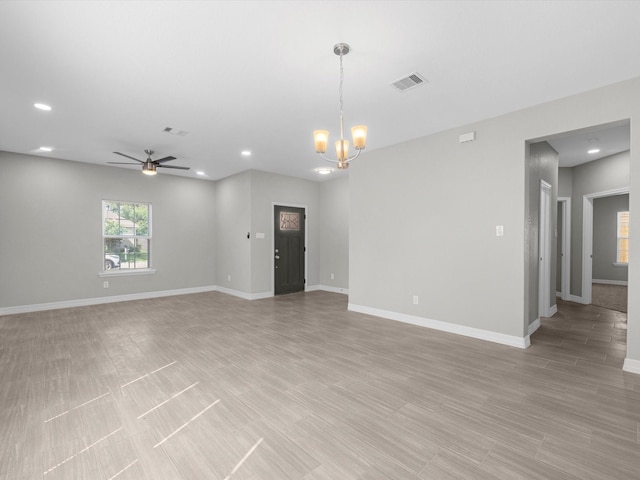 unfurnished room featuring light hardwood / wood-style floors and ceiling fan with notable chandelier