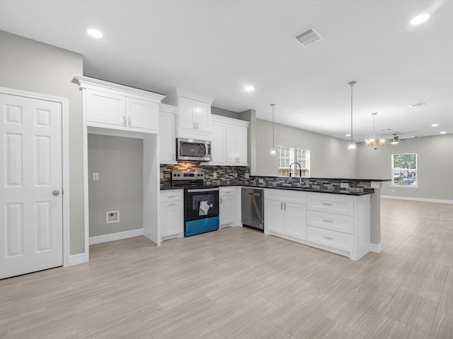 kitchen with stainless steel appliances, ceiling fan, sink, pendant lighting, and white cabinetry