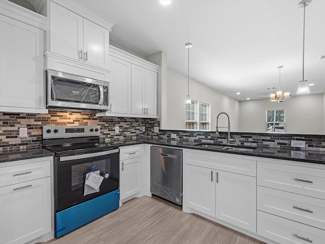 kitchen with sink, white cabinets, pendant lighting, and appliances with stainless steel finishes