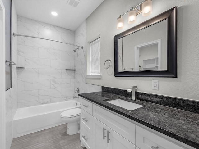 full bathroom with vanity, toilet, and tiled shower / bath combo