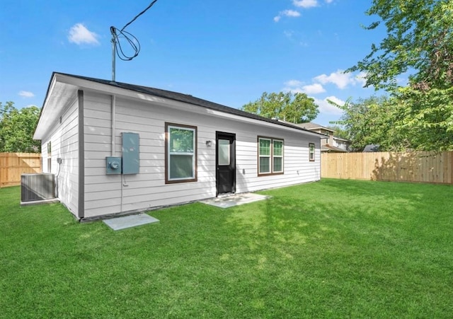 back of property with a yard and central AC unit