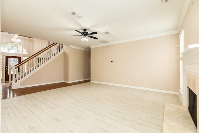 unfurnished living room with ceiling fan with notable chandelier, ornamental molding, a tile fireplace, and light hardwood / wood-style flooring