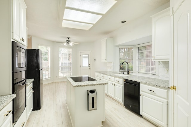 kitchen featuring sink, a center island, white cabinetry, and black appliances