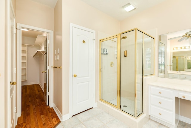 bathroom with ceiling fan, hardwood / wood-style floors, and walk in shower