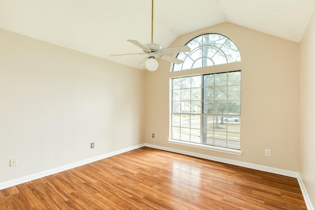 empty room featuring ceiling fan, light wood-type flooring, and vaulted ceiling