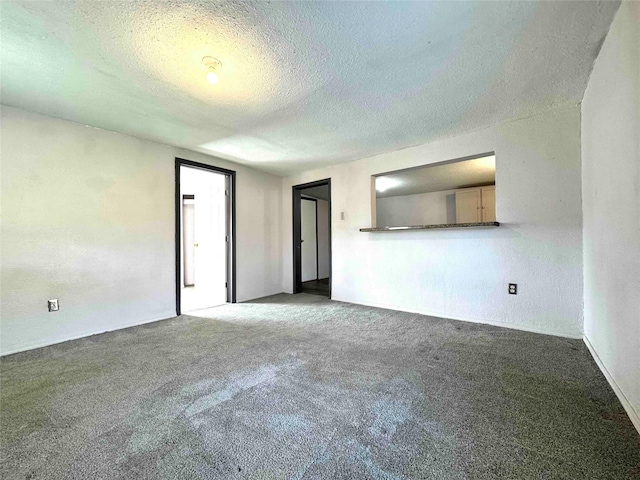 unfurnished room with carpet and a textured ceiling