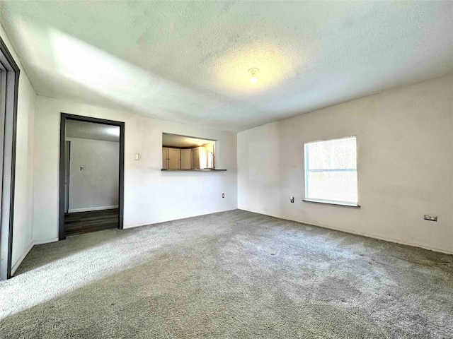 unfurnished living room featuring carpet and a textured ceiling