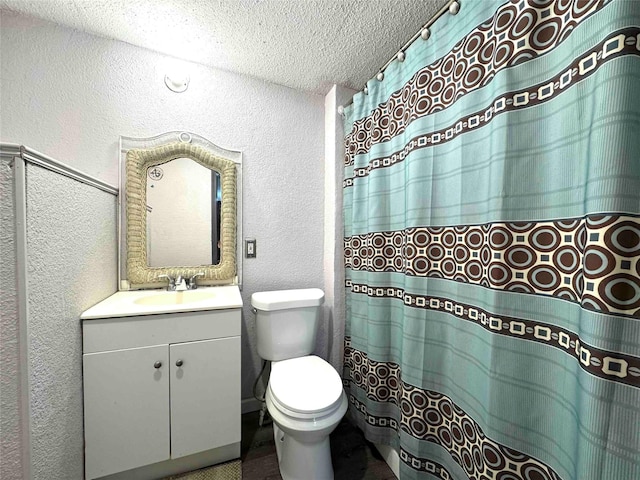 bathroom with vanity, a textured ceiling, and toilet