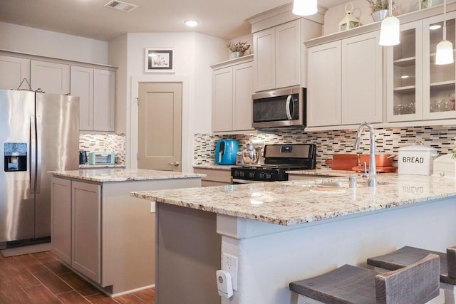 kitchen featuring backsplash, sink, hanging light fixtures, appliances with stainless steel finishes, and dark hardwood / wood-style flooring