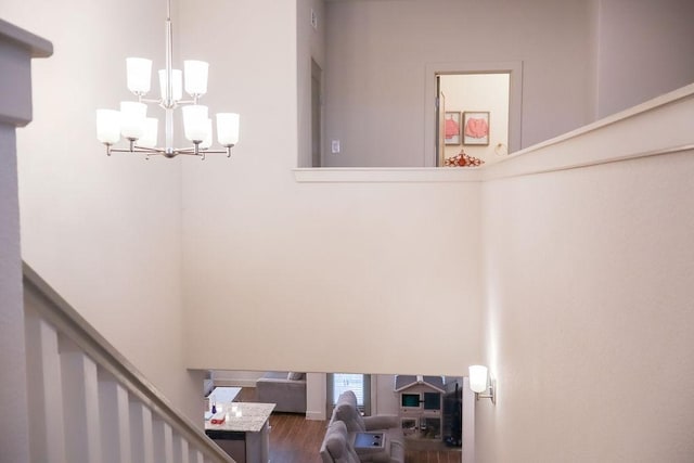 stairs with hardwood / wood-style flooring and a chandelier