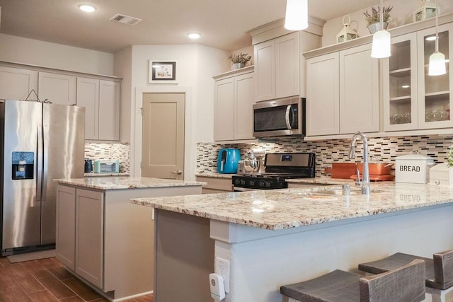 kitchen with tasteful backsplash, stainless steel appliances, dark wood-type flooring, sink, and hanging light fixtures