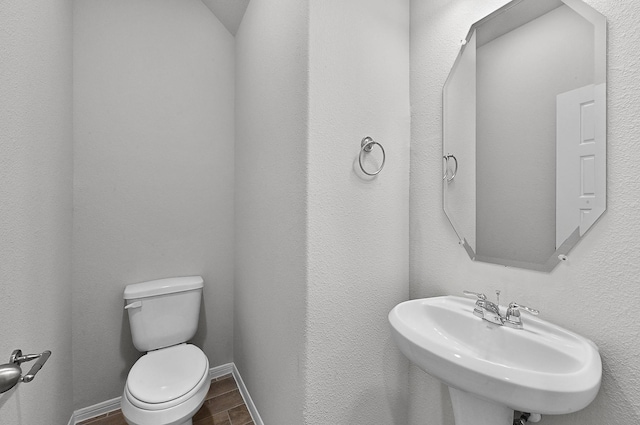 bathroom featuring toilet, wood-type flooring, and sink