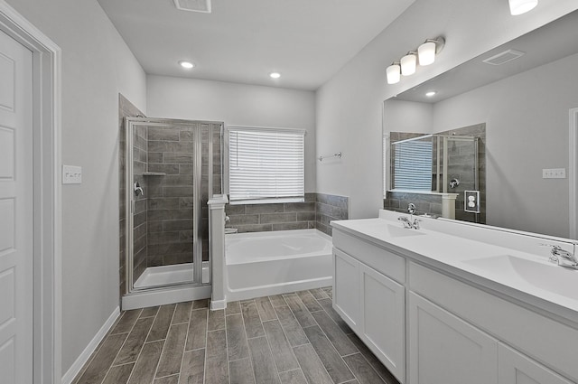 bathroom featuring plus walk in shower, vanity, and hardwood / wood-style flooring