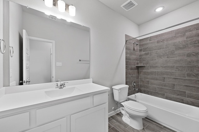 full bathroom with hardwood / wood-style flooring, vanity, toilet, and tiled shower / bath