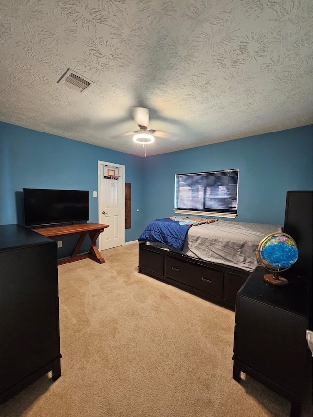 carpeted bedroom with a textured ceiling and ceiling fan