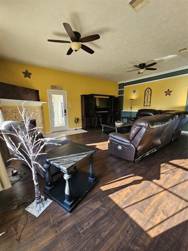 living room with dark hardwood / wood-style floors, ceiling fan, and a textured ceiling