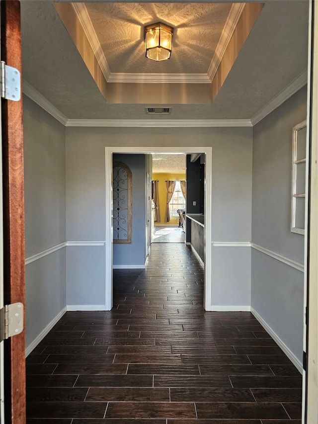 interior space featuring dark hardwood / wood-style floors, a raised ceiling, and crown molding