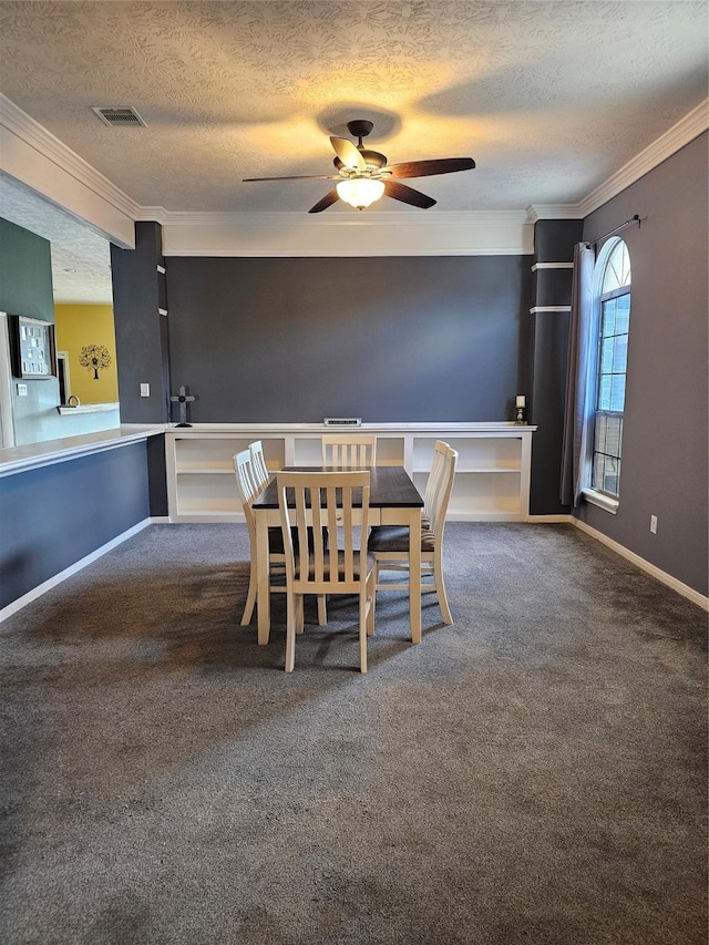 unfurnished dining area with dark colored carpet, a textured ceiling, and ornamental molding