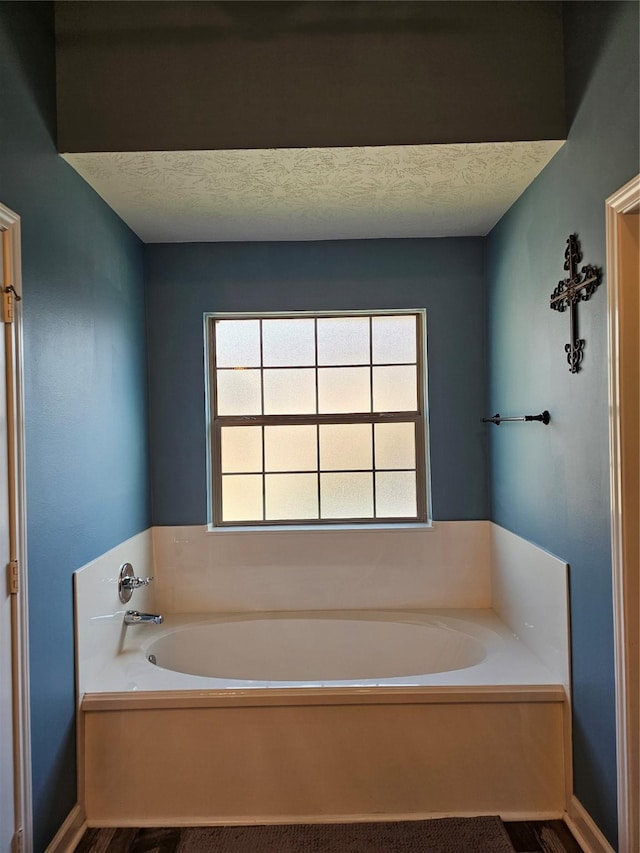 bathroom with a bath and a textured ceiling