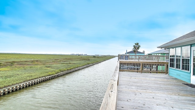 view of dock with a rural view and a water view