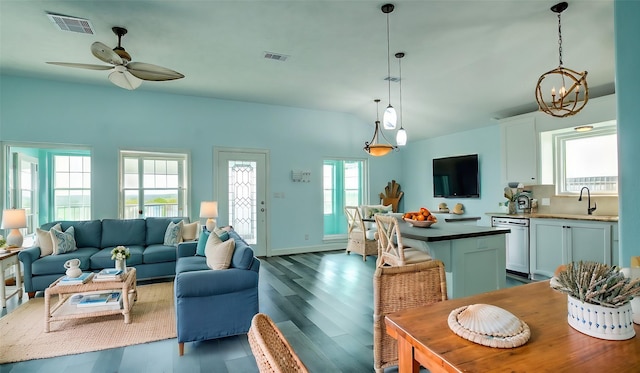 interior space with dishwasher, pendant lighting, ceiling fan with notable chandelier, white cabinets, and sink