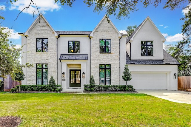 view of front of property with a front yard, french doors, and a garage