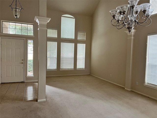 carpeted entryway with a wealth of natural light, a towering ceiling, and a notable chandelier