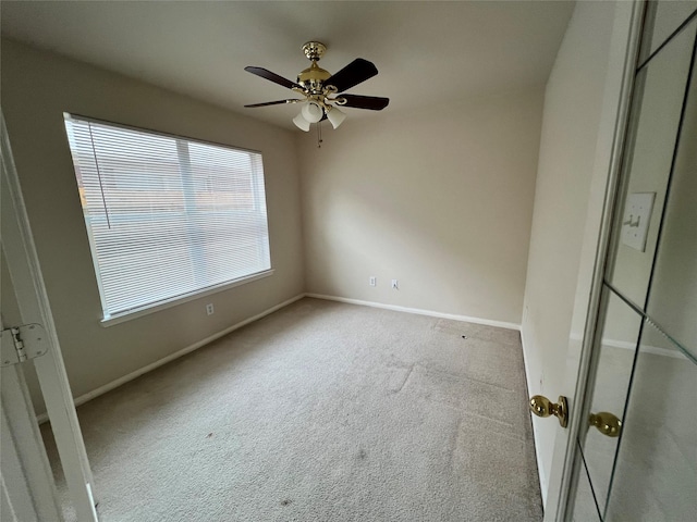 carpeted spare room with ceiling fan