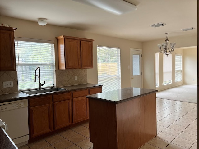 kitchen featuring dishwasher, sink, decorative backsplash, a notable chandelier, and light tile patterned flooring