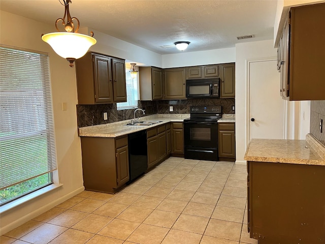 kitchen with sink, decorative light fixtures, a healthy amount of sunlight, and black appliances