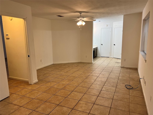 spare room featuring ceiling fan and light tile patterned floors