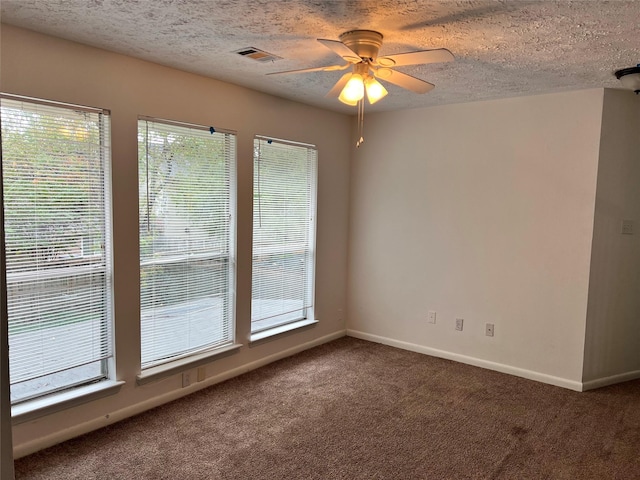 empty room featuring a healthy amount of sunlight and dark colored carpet