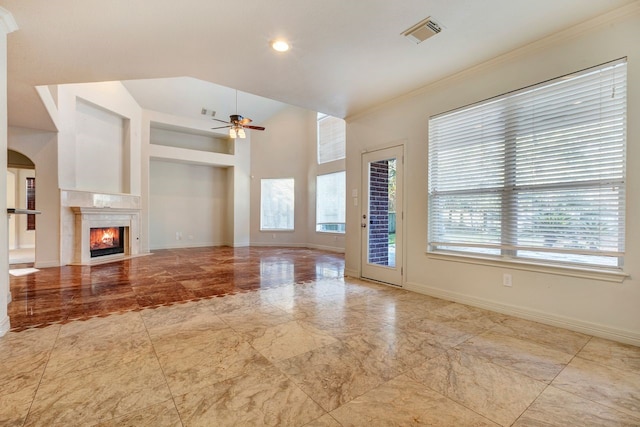 unfurnished living room with ceiling fan, a premium fireplace, and crown molding