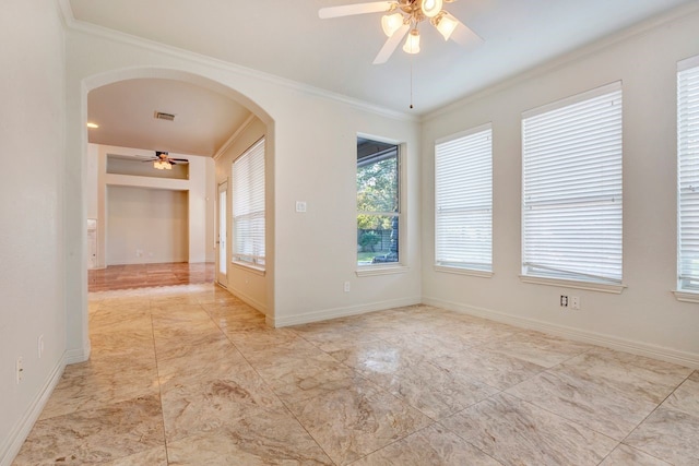 empty room featuring ceiling fan and crown molding