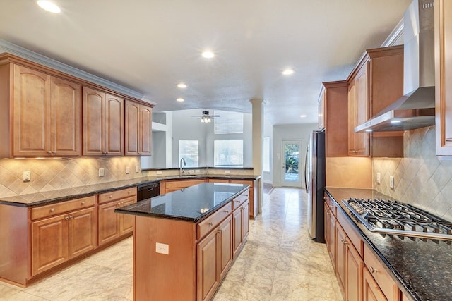 kitchen featuring sink, wall chimney exhaust hood, tasteful backsplash, dark stone counters, and appliances with stainless steel finishes