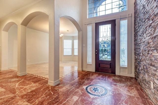 entryway featuring crown molding and a high ceiling