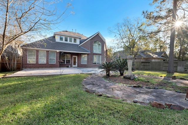 rear view of house with a yard and a patio