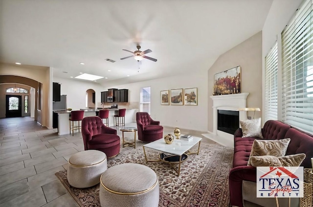 living room featuring ceiling fan and lofted ceiling