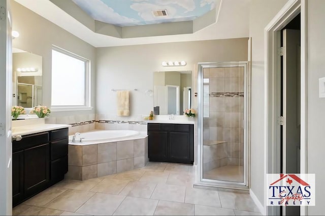 bathroom with tile patterned floors, vanity, separate shower and tub, and a tray ceiling