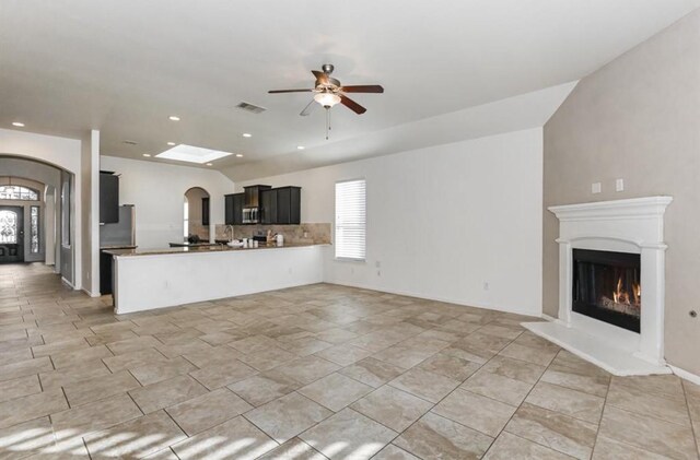 kitchen with kitchen peninsula, ceiling fan, plenty of natural light, and stainless steel appliances