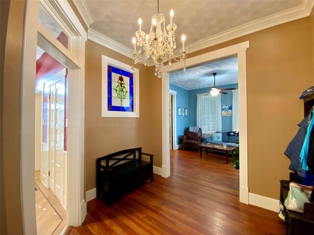 hall featuring crown molding, hardwood / wood-style floors, and an inviting chandelier