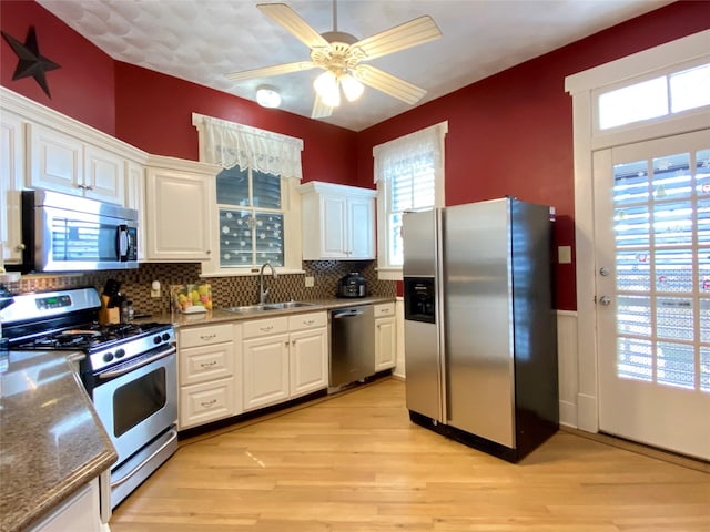 kitchen with sink, stainless steel appliances, light hardwood / wood-style flooring, backsplash, and white cabinets