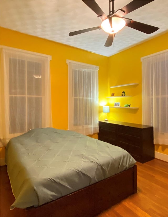 bedroom with hardwood / wood-style floors and ceiling fan