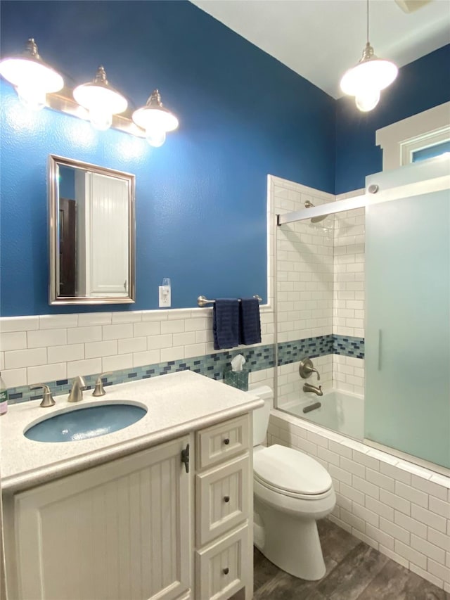 full bathroom featuring toilet, vanity, combined bath / shower with glass door, and hardwood / wood-style flooring