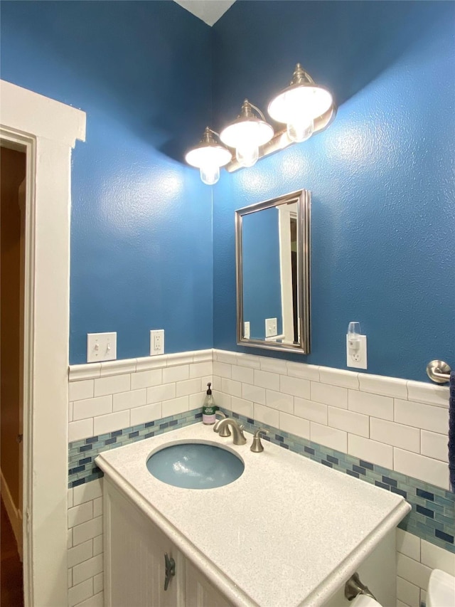 bathroom featuring vanity and tile walls