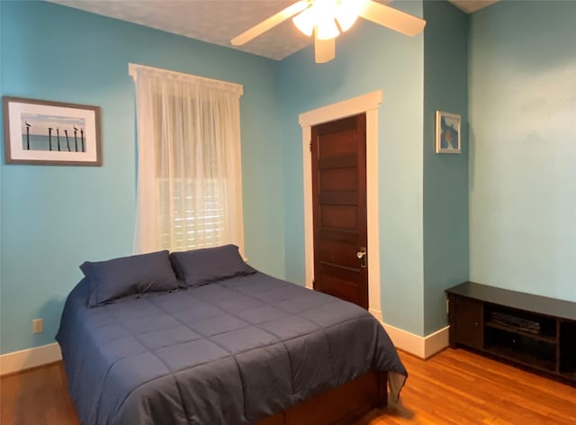 bedroom with hardwood / wood-style floors and ceiling fan