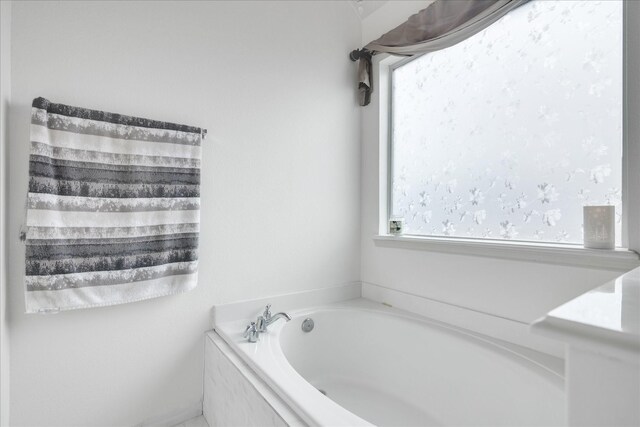 bathroom with a relaxing tiled tub