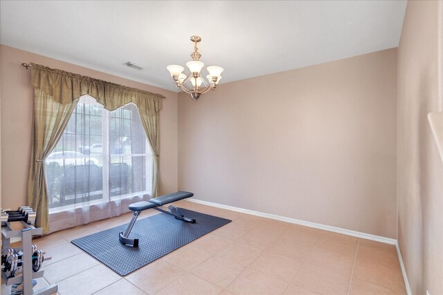 workout area featuring light tile patterned floors and an inviting chandelier