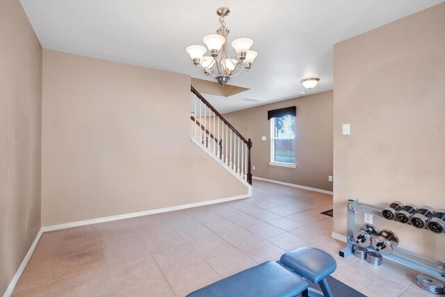 exercise area with tile patterned floors and an inviting chandelier